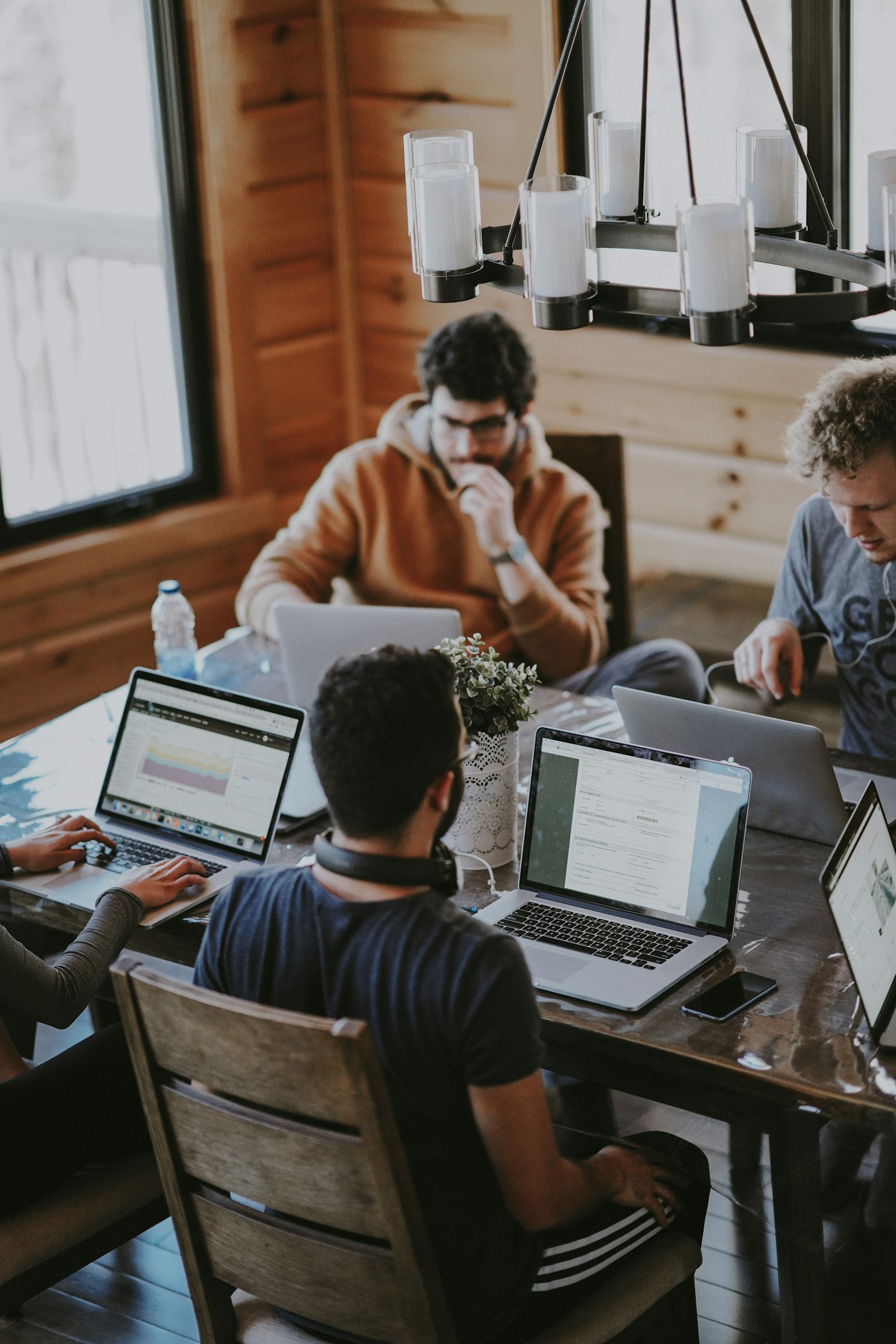 Small group working around laptops at a shared table; illustrative stock photograph